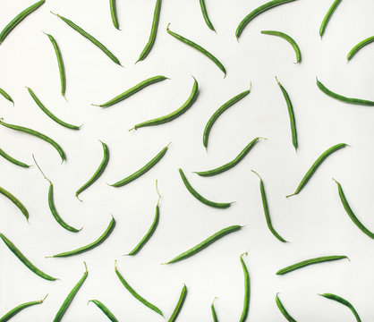 Food pattern, texture and background. Flat-lay of fresh green beans over white wooden background, top view. Healthy cooking, clean eating, vegan, vegetarian, dieting concept