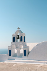Fototapeta na wymiar White church bell tower with blue sky in Oia, Santorini, Greece