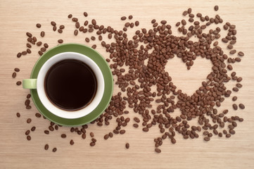 Green coffee cup on the table and coffee heart