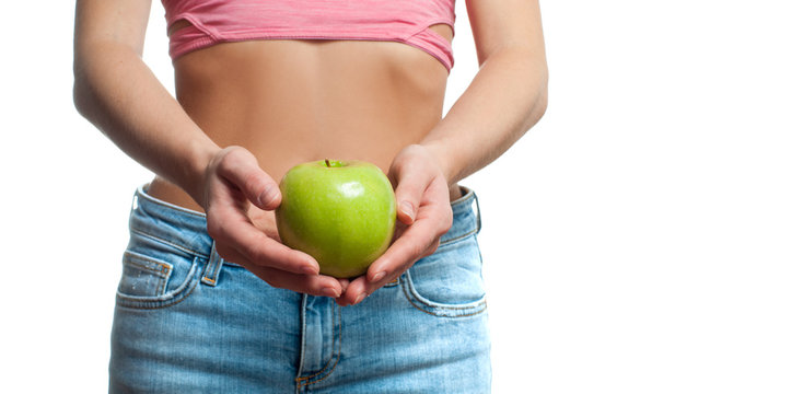 Diet concept. Beautiful woman with slim waist is holding apple