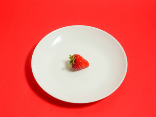 A strawberry and fork, Strawberry of the dessert　フォークとイチゴ、デザートのイチゴ、レストランのイチゴなど　赤色背景