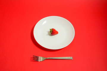 A strawberry and fork, Strawberry of the dessert　フォークとイチゴ、デザートのイチゴ、レストランのイチゴなど　赤色背景