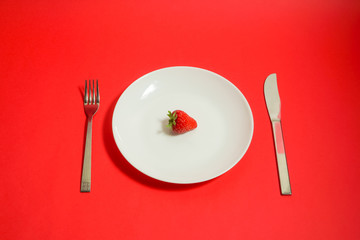 A strawberry and fork, Strawberry of the dessert　フォークとイチゴ、デザートのイチゴ、レストランのイチゴなど　赤色背景