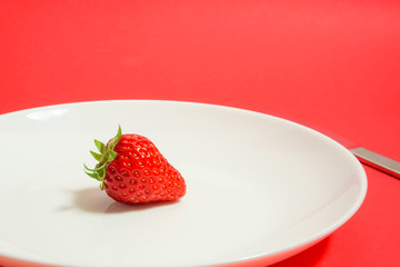 A strawberry and fork, Strawberry of the dessert　フォークとイチゴ、デザートのイチゴ、レストランのイチゴなど　赤色背景