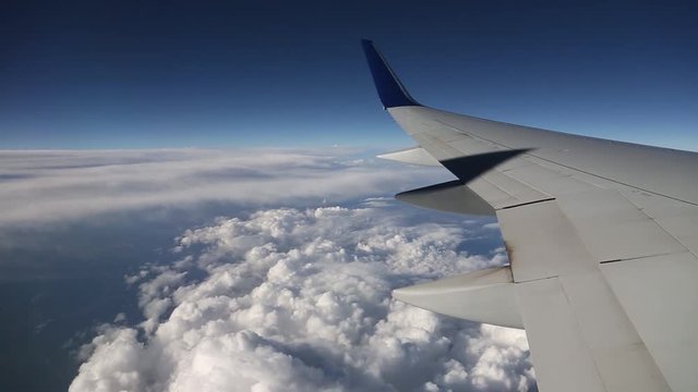 Air travel, view of sky and wing from airplane jet window.