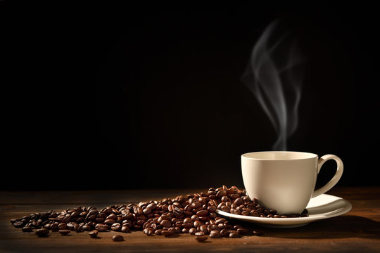 Fototapeta Filiżanka kawy z dymem i kawowymi fasolami na czarnym tle, Ten wizerunek bez dymu jest dostępny