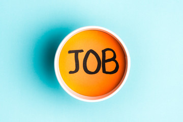 Job text orange into paper cup over blue background