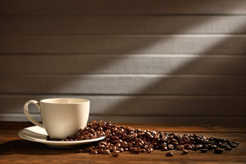 Coffee cup and coffee beans on old wooden background