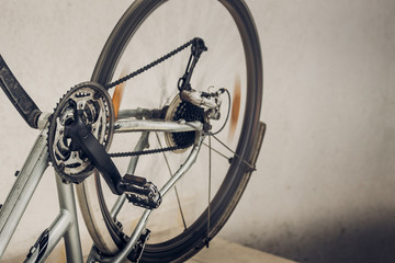 Turning wheel, pedals and chain of dirty broken inverted bicycle