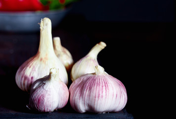 Aromatic garlic on a dark table with red pepper