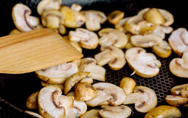 Fried mushrooms in a hot frying pan on an electric stove
