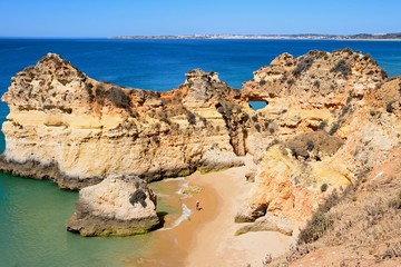 Yachts moored in the marina with a parasailing boat full of tourists in the foreground, Albufeira, Algarve, Portugal.