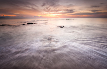Obraz premium long expose sunset seascape with waves trails. image contain soft focus due to long expose.