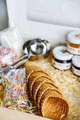 waffle ice cream cups in a gift box with a spoon for ice cream, topping and confectionery sprinkles
