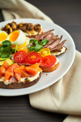 Bruschetta, assorted, different fillings, on plates with a soft-boiled egg in the middle