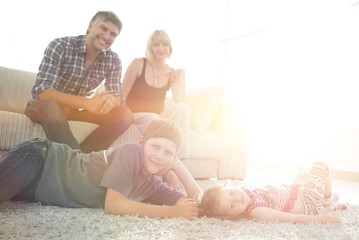 Portrait of children while parents sitting at sofa in living roo