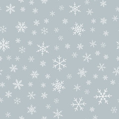 White snowflakes seamless pattern on light grey Christmas background. Chaotic scattered white snowflakes. Interesting Christmas creative pattern. Vector illustration.