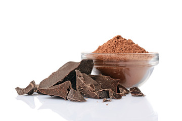 Close-up pieces of chunk black chocolate with glass bowl of cocoa powder