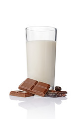 Close-up pieces of chocolate bar with cocoa beans and glass of milk
