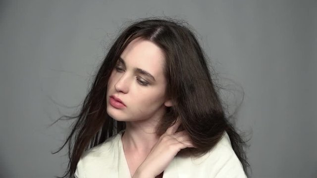 Slow motion video portrait of beauty young brunette woman with green eyes and streaming hair