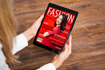 Woman reading fashion magazine on tablet