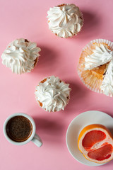   Coffee espresso in a white cup and cakes with meringues on a pink background. Gentle colors. Elegant  dessert. Serving option. Holiday. Wedding table. Sliced grapefruit. Flat lay