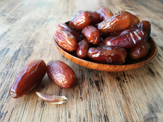 Dates in a wooden plate  on a wooden table