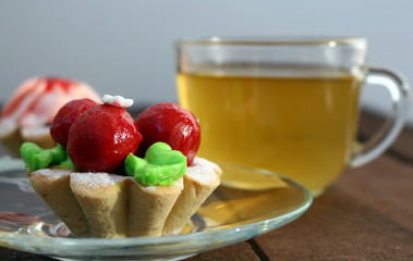 bright cakes in the form of baskets on the background of a dark wooden table with tea