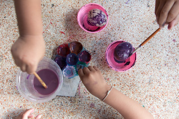 The children are painting The Easter eggs for funny.