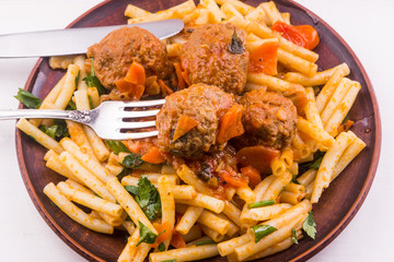 Macaroni with meatballs in tomato sauce - top view
