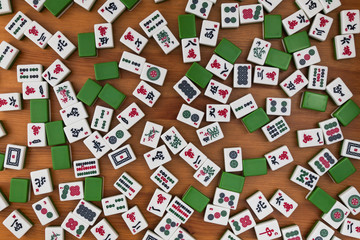 White-green tiles for mahjong on a brown wooden background. No empty place.