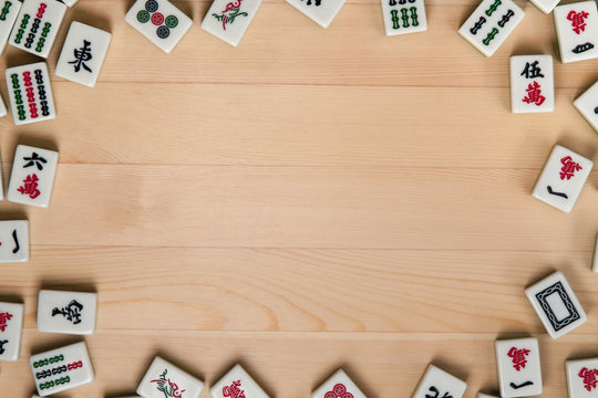 White-green tiles for mahjong on a background of light brown wood. Empty space in the center