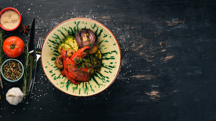 Grilled vegetables. Garnish. Top view. On a black wooden background. Copy space.