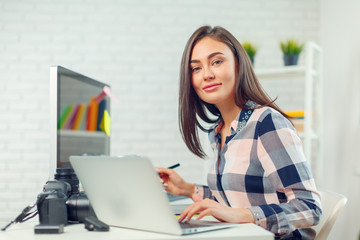 pretty young woman photographer with camera in office