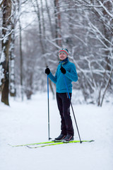 Photo of male skier in blue jacket at winter forest