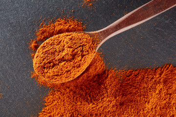 Texture background. Red chilli pepper powder mixed with wooden spoon. Top view