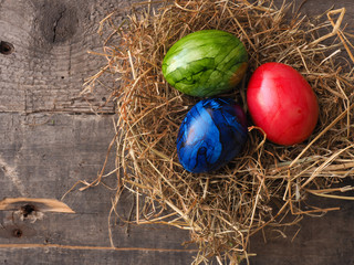 Fototapeta na wymiar Three colored Easter eggs in a nest