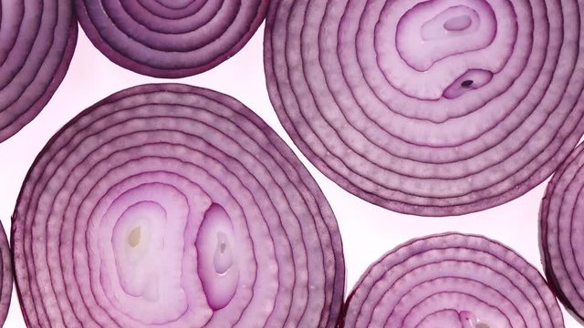Sliced red onion rotation on white background in 4K. Closeup top view.
