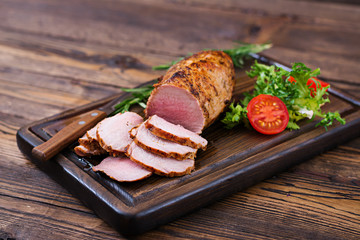 Baked juicy veal fillet in spices on a wooden table. Medium Well. - obrazy, fototapety, plakaty