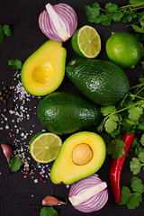 Guacamole sauce ingredients - avocado,  onion, pepper chili, garlic, cilantro, lime on black background. Top view