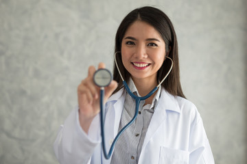 Doctor smiling woman holding a stethoscope in hand.