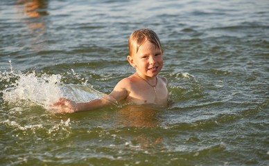 The boy is swimming in the sea.