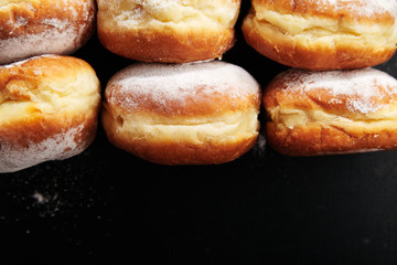 Closeup shot of sufganiyot donuts with jelly on black background