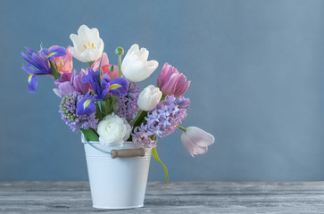 spring flowers in bucket on blue background