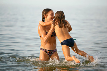 Girls sisters have fun bathing in the sea