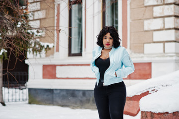 Stylish african american plus size model at streets of city on winter day.