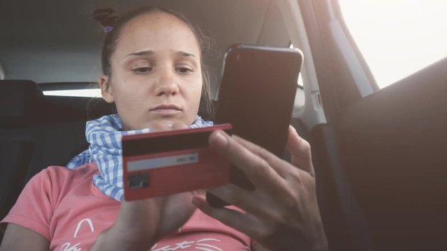 Young woman paying via app for taxi cab ride uses a credit card. 3840x2160