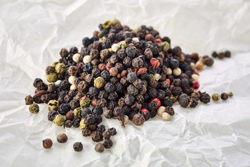 Top view on black, red and white peppercorns isolated on white background, shallow depth of field.