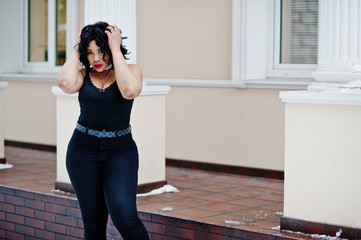 Stylish african american plus size model at streets of city on winter day.