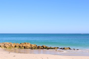 Fototapeta na wymiar Beautiful white sand beach with turquoise water under blue skies